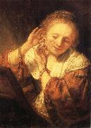 REMBRANDT Harmenszoon van Rijn Young Woman Trying on Earrings oil painting on canvas
